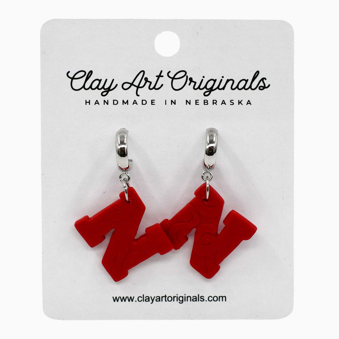Red letter 'W' earrings on a Clay Art Originals card.