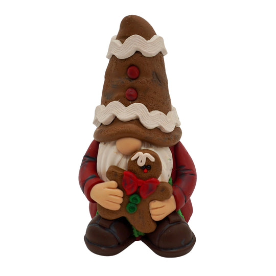 Gnome figurine with a gingerbread hat and cookie on a white background