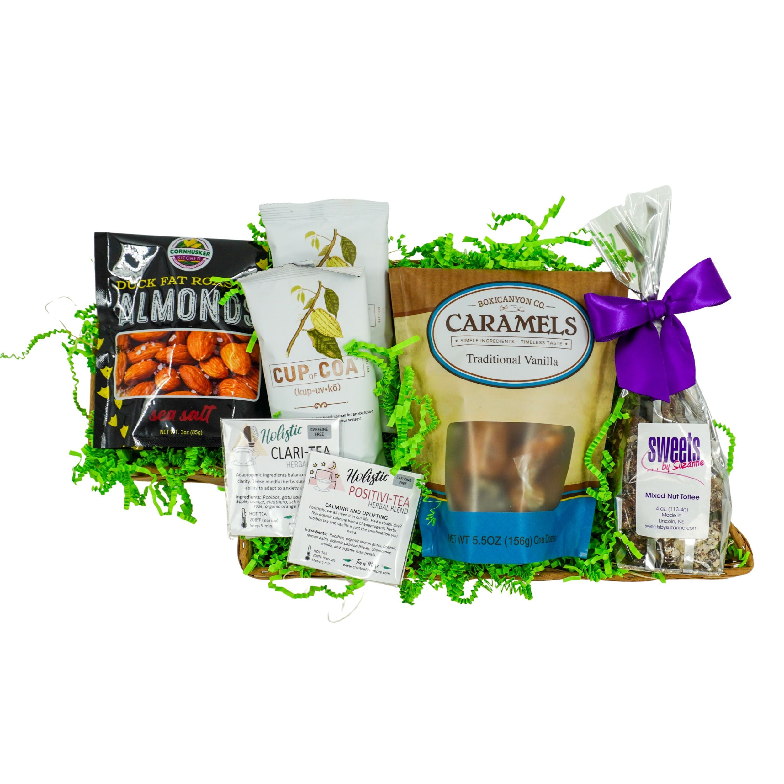 Gourmet gift basket with caramels, cookies, and other snacks on a white background