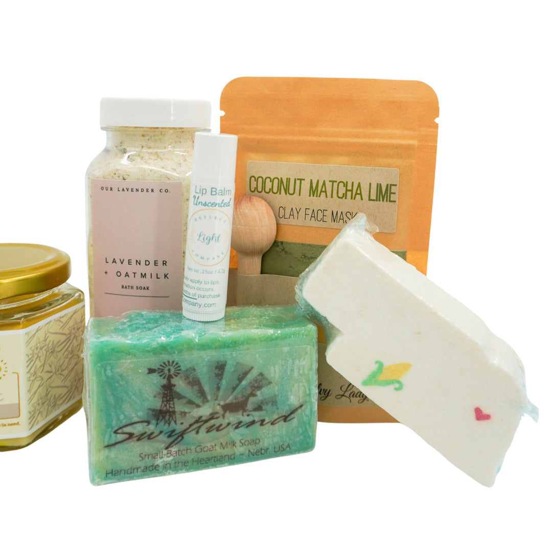 Collection of natural skincare and beauty products including soap, face mask, and lip balm on a white background.