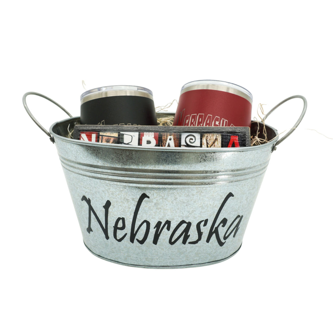 Metal bucket with 'Nebraska' text containing tumblers on a white background
