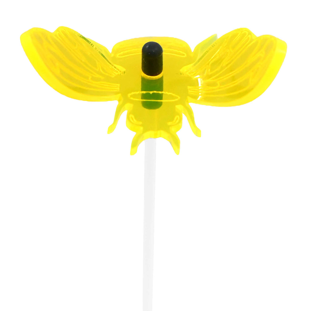 Yellow bee-shaped straw with a white handle on a white background
