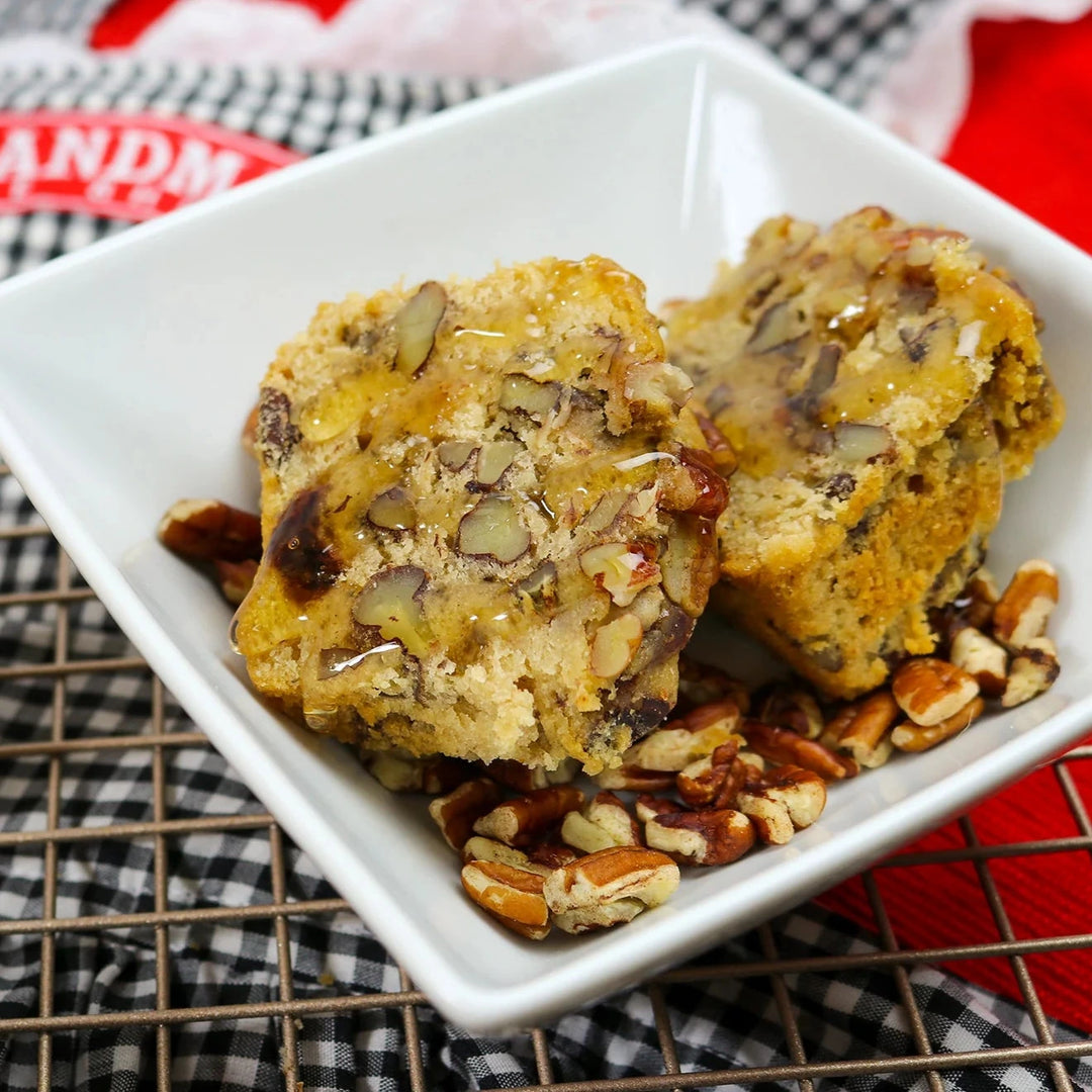 Pecan cake on a white plate with a checkered towel in the background