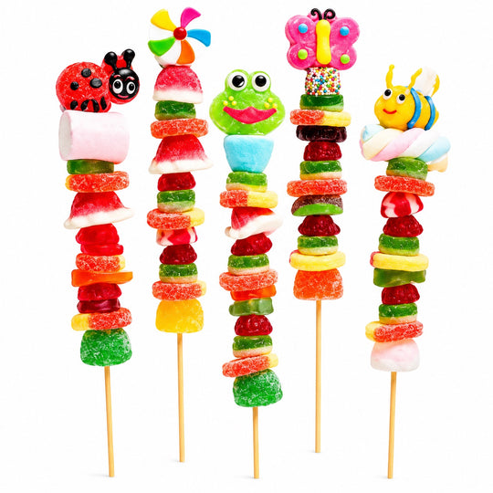 Collection of five colorful candy kabobs featuring ladybug, beach ball, frog, butterfly, and bee candy toppers, arranged side by side on wooden skewers against a clean white background.