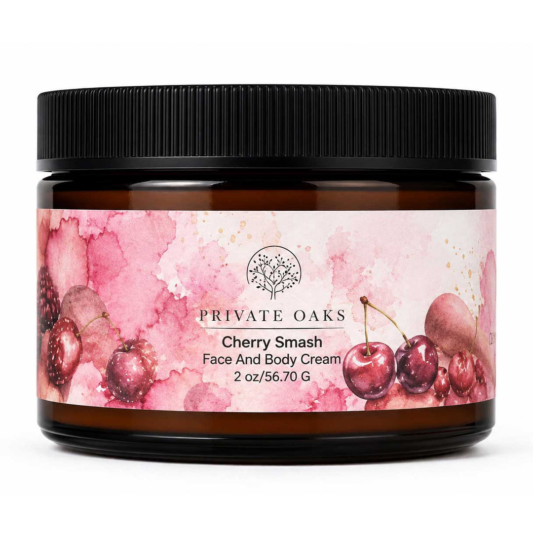 A jar of Private Oaks Cherry Smash Face And Body Cream, featuring a pink watercolor cherry label on an amber glass jar with a black lid, set against a plain white background.