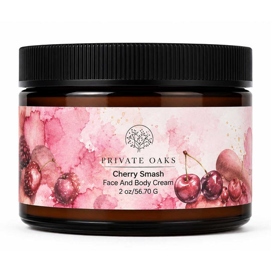 A jar of Private Oaks Cherry Smash Face And Body Cream, featuring a pink watercolor cherry label on an amber glass jar with a black lid, set against a plain white background.