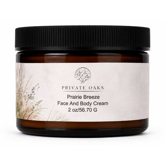 A jar of Private Oaks Prairie Breeze Face And Body Cream in an amber glass jar with a black ribbed lid and a textured off-white label, shown on a white background.