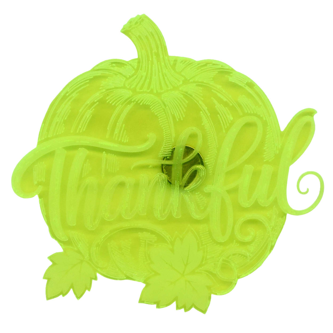 A bright neon yellow-green decorative sign shaped like a pumpkin with the word 'Thankful' in cursive script and small leaf accents, shown on a plain white background.