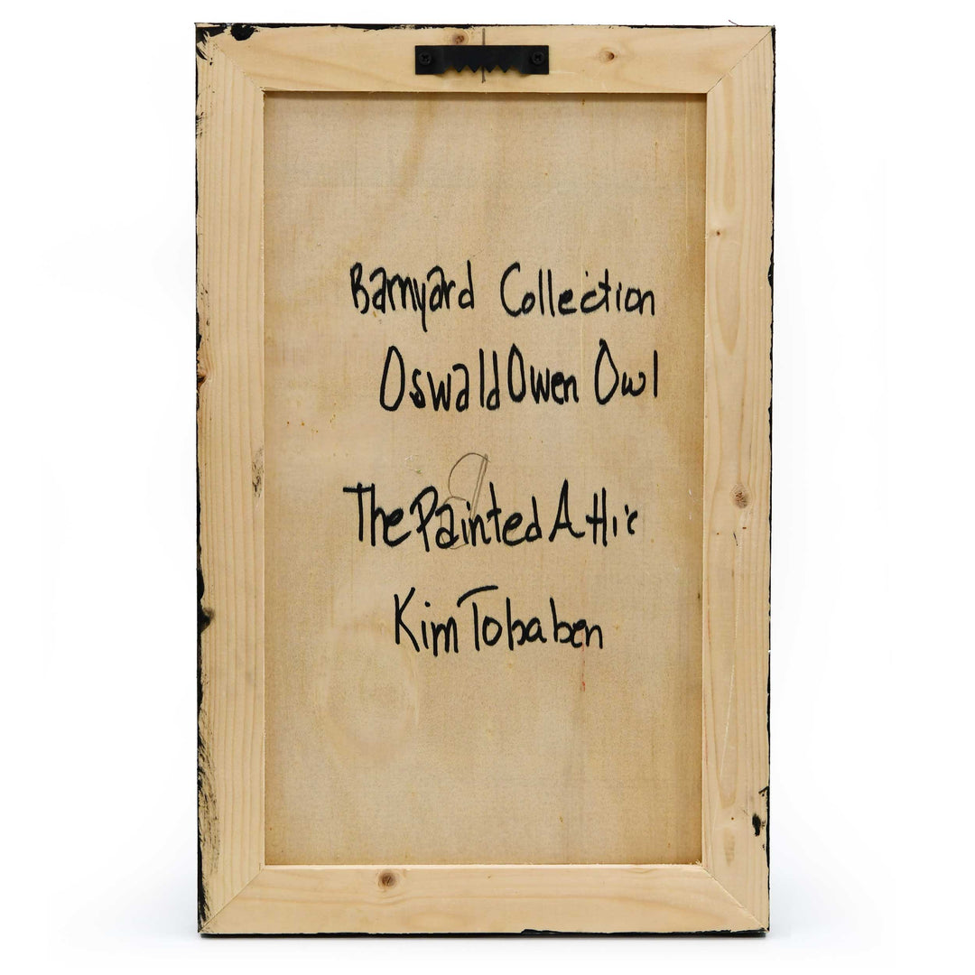 Wooden frame with engraved text that says "Barnyard Collection Oswald Owen Owl The Painted Attic Kim Tobaben" on a white background