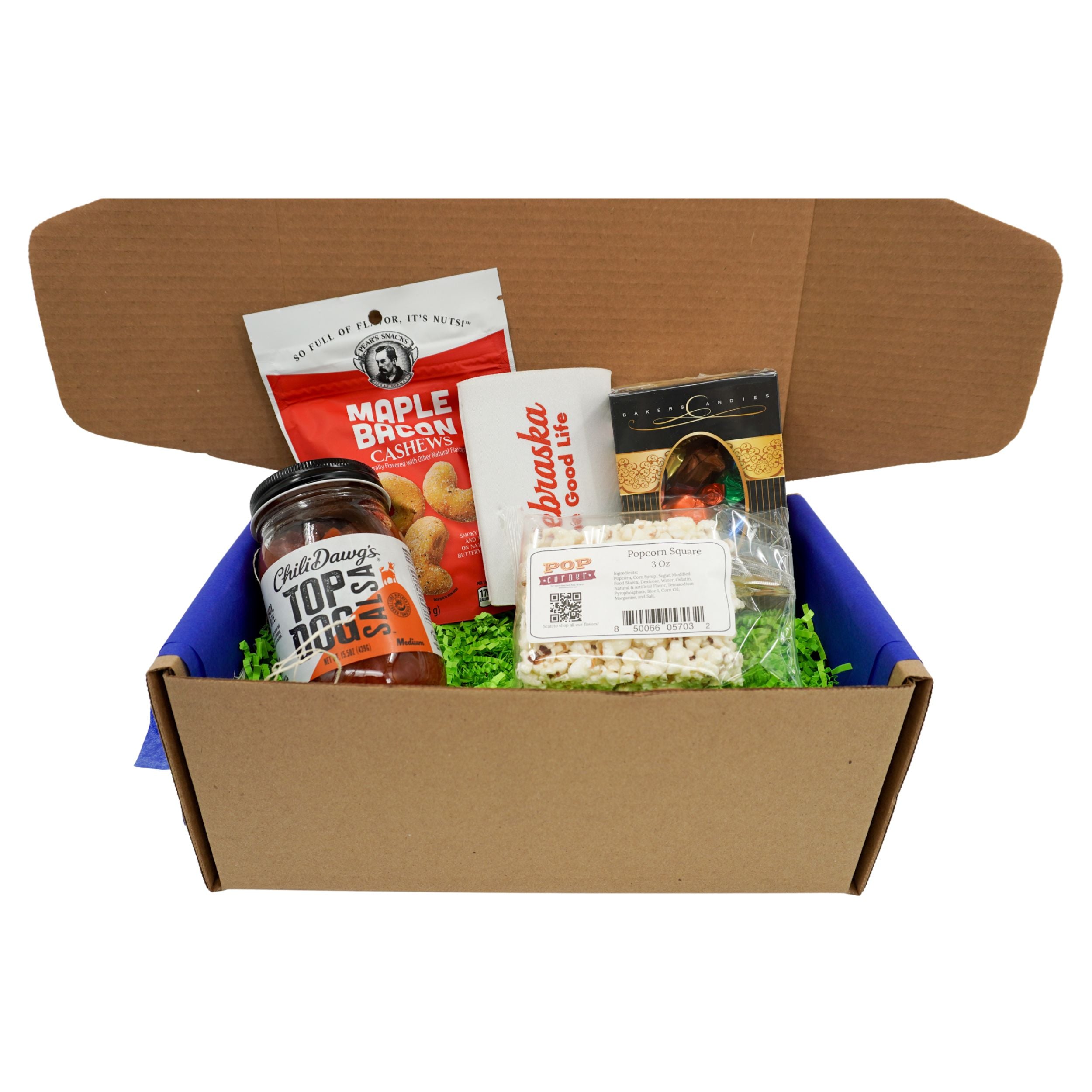Cardboard box with food items including a jar, a bag, and a box on a white background