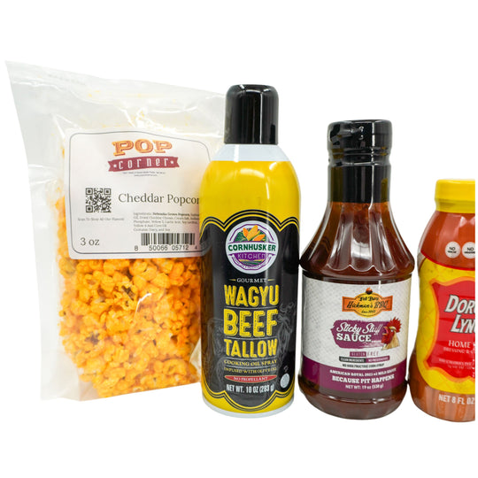 Packaged cheddar popcorn and three bottles of different products on a white background