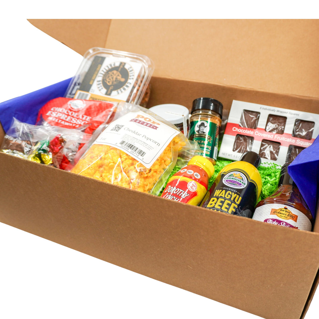 Open cardboard box filled with various Nebraska food items and products.