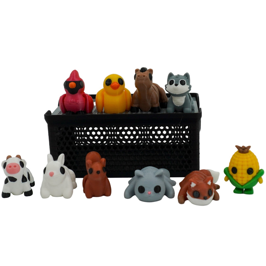 Collection of small animal figurines in front of a black box on a white background