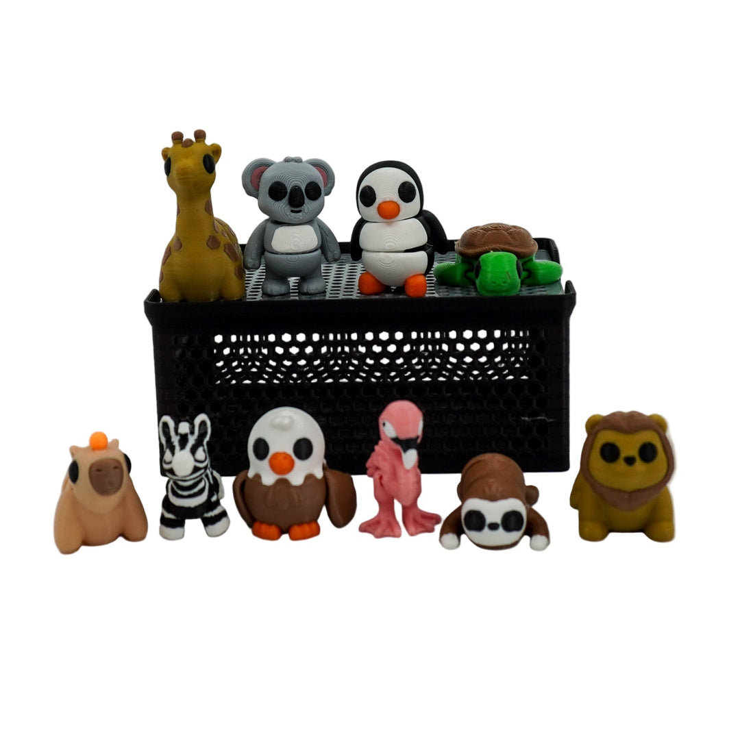 Collection of small animal figurines in front of a black rectangular container on a white background