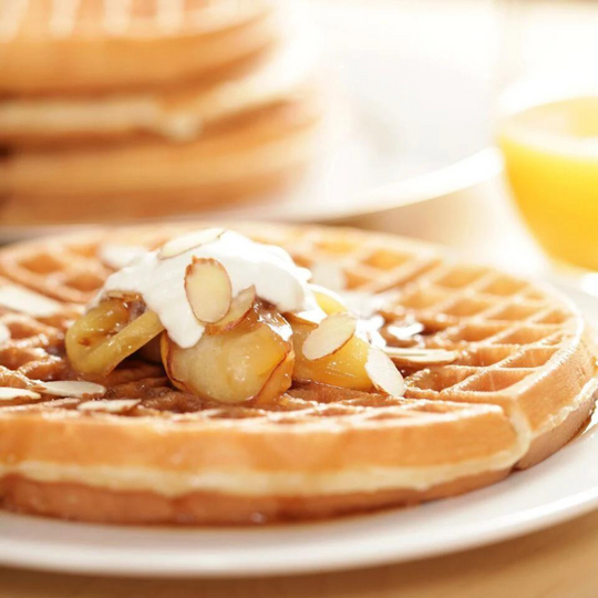 Belgian Waffles on a white plate with toppings on top.