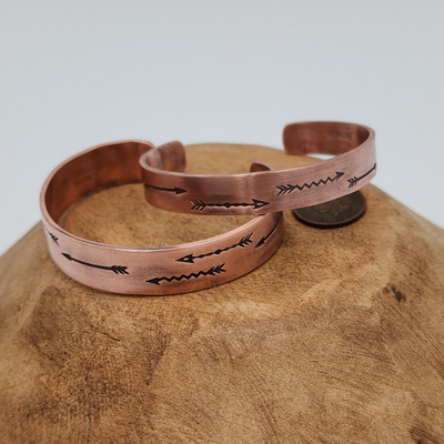 2 Hand Stamped Arrow Design Copper Bracelet on Wood with Coin for Comparison