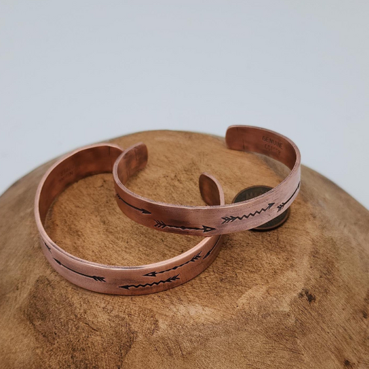 2 Hand Stamped Arrow Design Copper Bracelet on Wood with Coin for Comparison