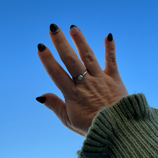 Sterling Silver Opal Ring on Hand with blue sky background