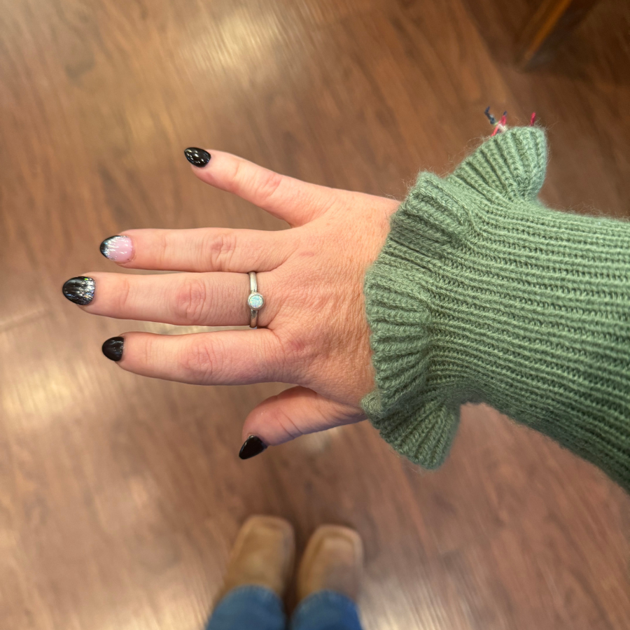 Sterling Silver Opal Ring on Hand with wood floor background