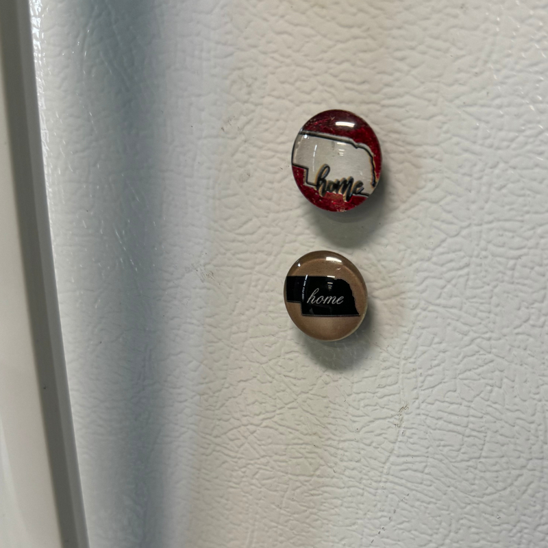 2 Home Magnets With Nebraska State Outline Red and Tan on fridge