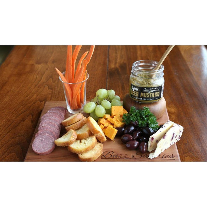 Spicy Beer Mustard Pictured On A Board With Carrots, Grapes, Cheese, Olives, & Summer Sausage