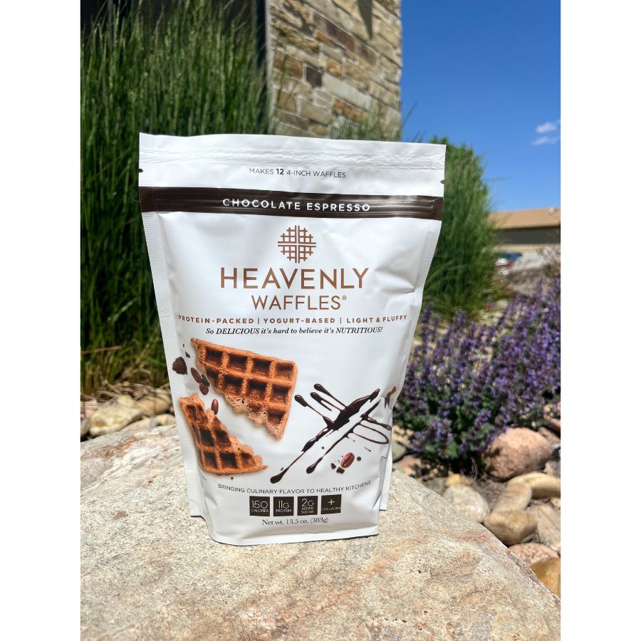 One 13.5 oz. Chocolate Espresso Heavenly Waffles Mix Pictured Outside On A Rock With A Floral Background