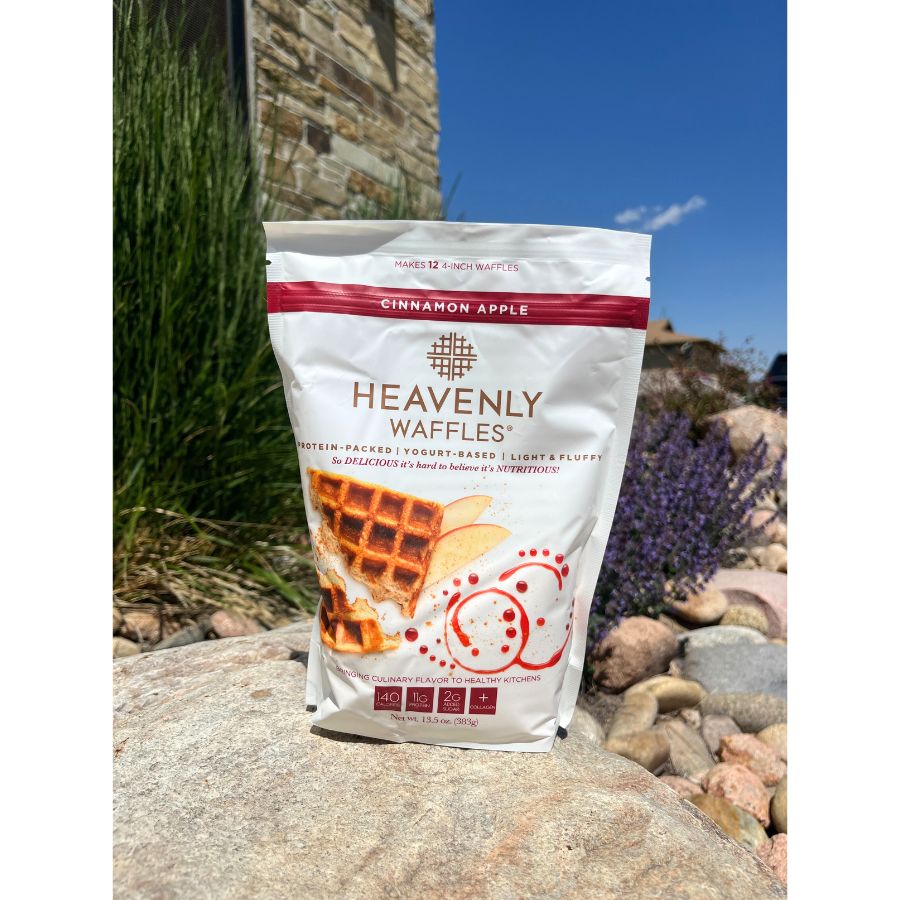 One 13.5 oz. Bag of Cinnamon Apple Heavenly Waffles Mix Outside On A Rock WIth A Floral Background