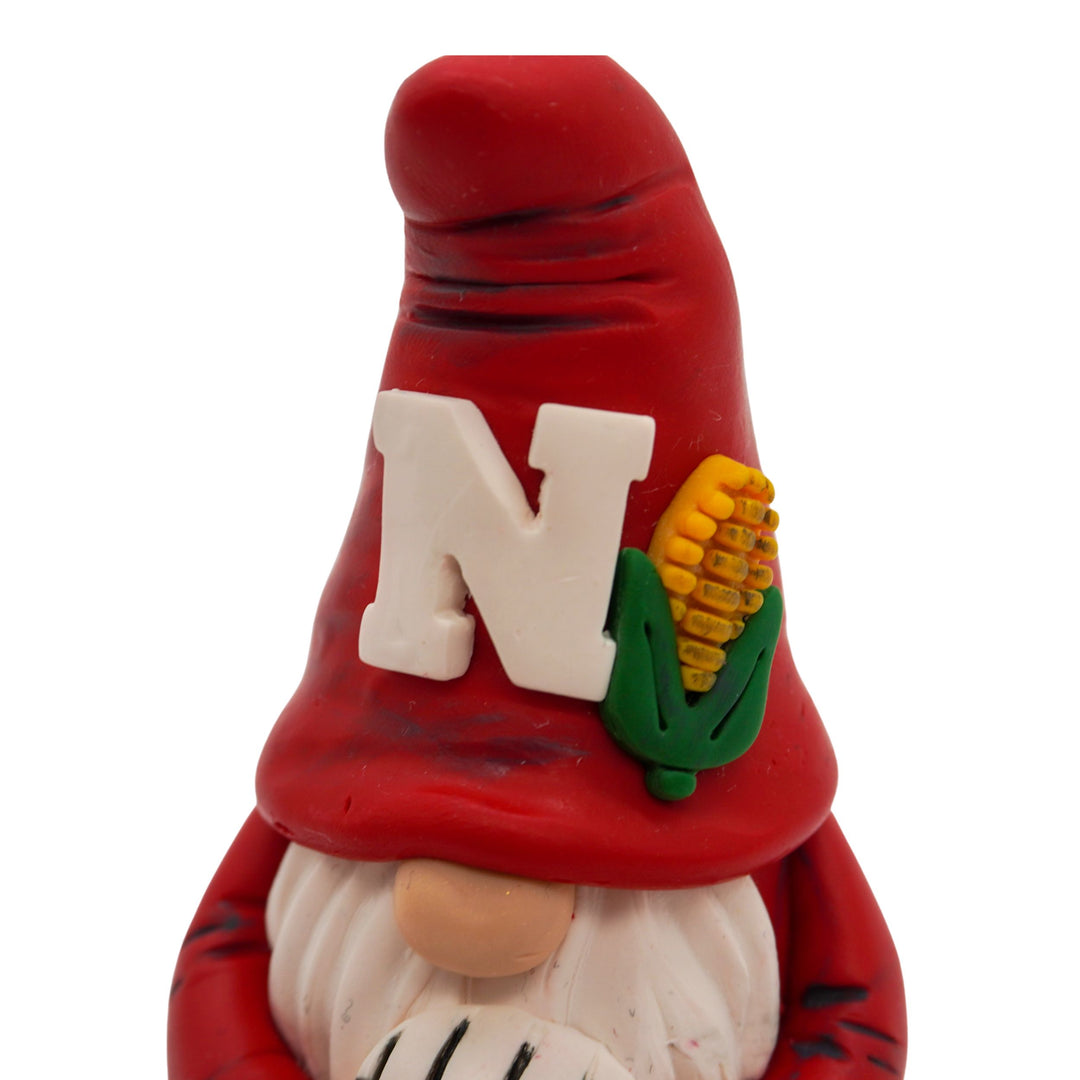 Gnome volleyball figurine with a red hat featuring a white 'N' and corn, on a white background