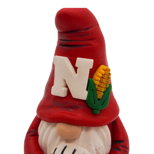 Gnome volleyball figurine with a red hat featuring a white 'N' and corn, on a white background