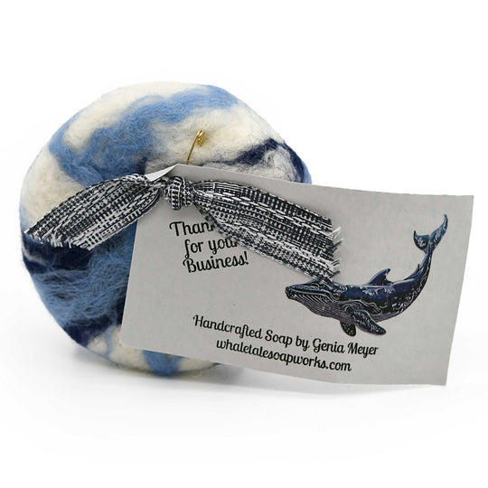 Blue and white felted soap with a bow and business card on a white background