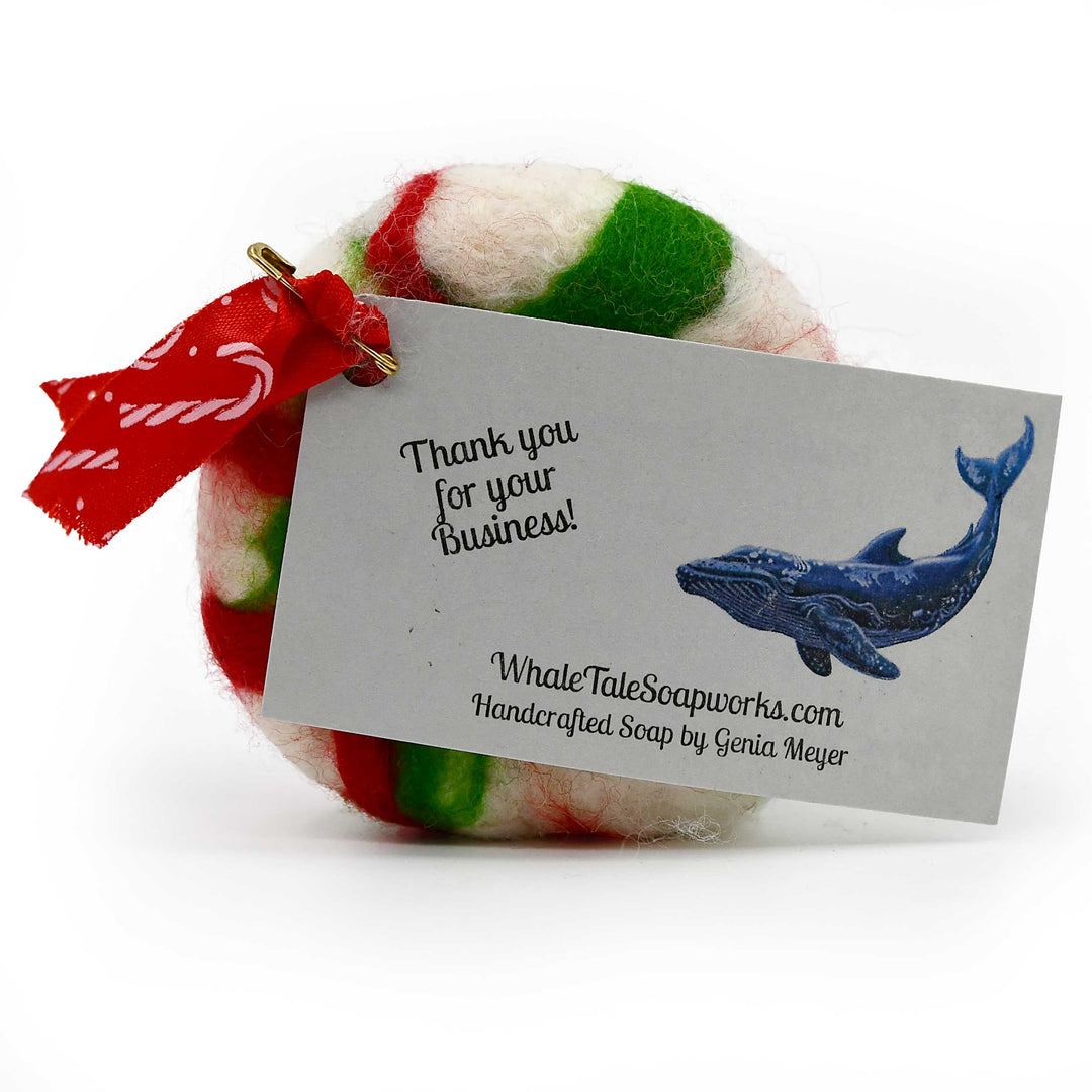 Colorful felted soap with a business card from Whale Tale Soapworks on a white background
