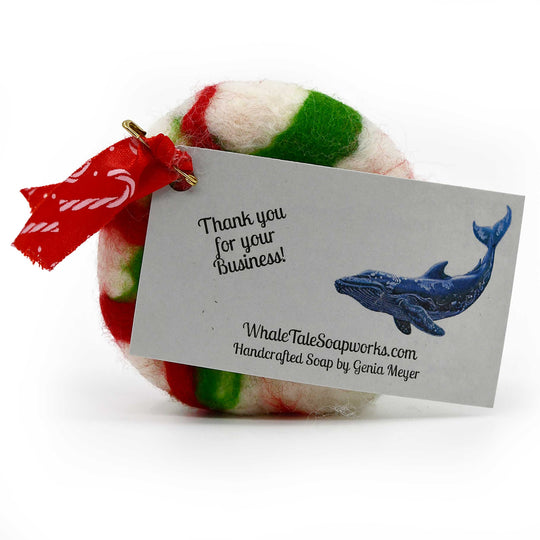 Colorful felted soap with a business card from Whale Tale Soapworks on a white background