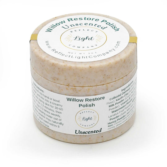 A round jar of Willow Restore Polish Unscented by Reflect Light Company, showing a textured beige polish inside and a white label with green and black text, wrapped in a gold band.
