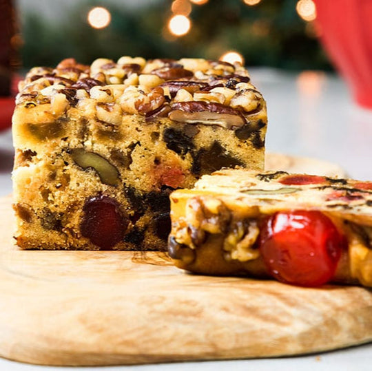 Fruitcake on a wooden board with a festive background