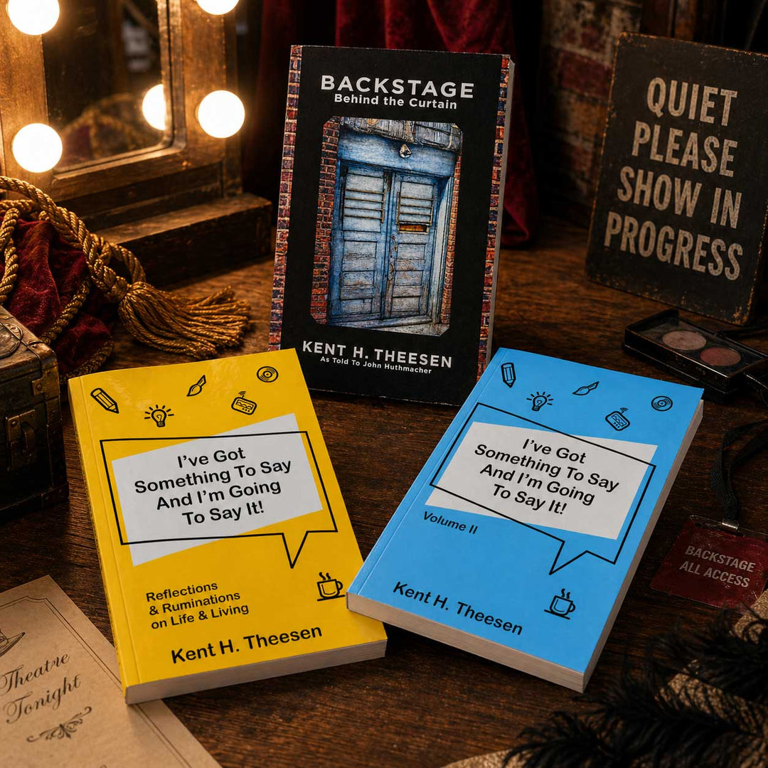 Three books by Kent H. Theesen on a wooden surface with decorative lights and signs in the background.