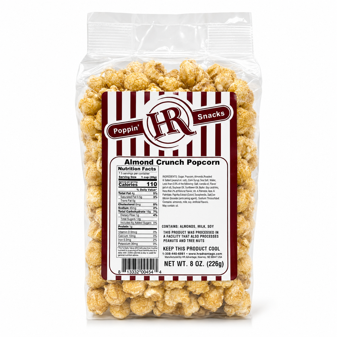 A 8 oz clear plastic bag of Poppin' HN Snacks Almond Crunch Popcorn, showing the back of the package with nutrition facts and product details, filled with golden-brown coated popcorn on a white background.