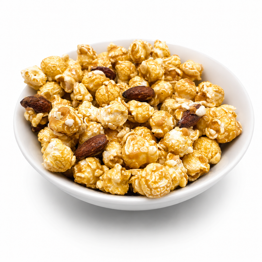 Caramel popcorn mixed with almonds in a white bowl on a white background.