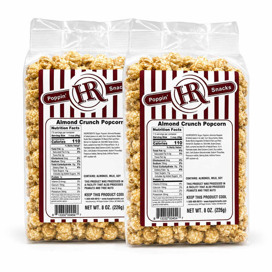 Two clear plastic bags of Poppin' HR Snacks Almond Crunch Popcorn on a white background, showing the product packaging and the popcorn inside.