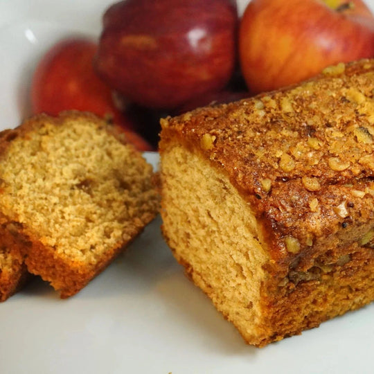 Loaf of bread with apples on a white plate