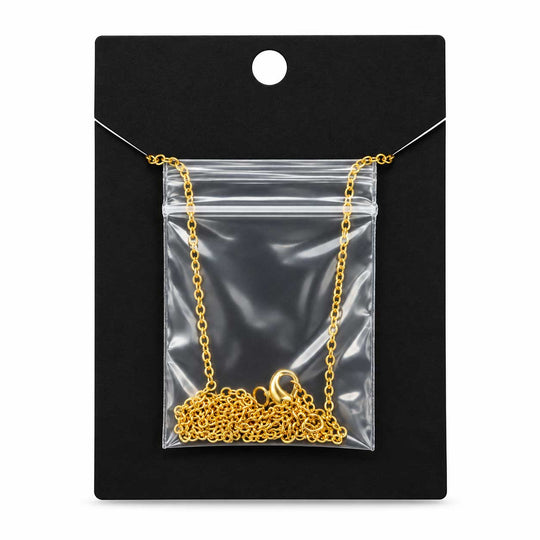 A gold chain necklace displayed inside a clear plastic zip pouch on a black hanging card.