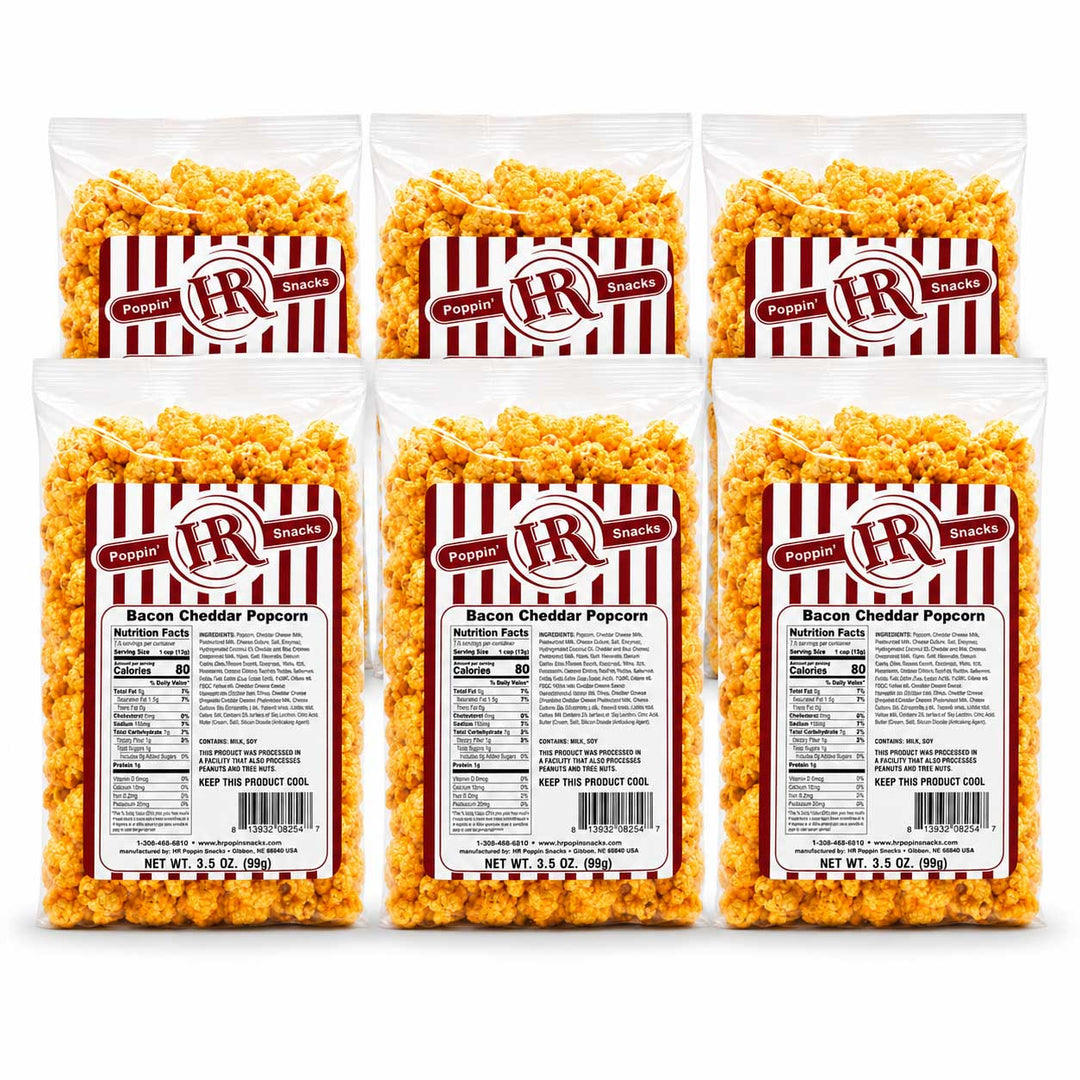 Six bags of Poppin' Brands Bacon Cheddar Popcorn arranged in two rows of three on a white background, showing the product packaging and the golden-yellow popcorn inside.