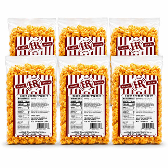 Six bags of Poppin' Brands Bacon Cheddar Popcorn arranged in two rows of three on a white background, showing the product packaging and the golden-yellow popcorn inside.