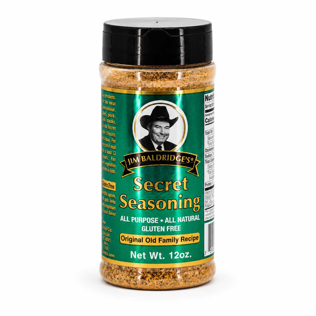 A 12 oz plastic shaker bottle of Jim Baldridges Secret Seasoning with a black lid and a green label, shown on a white background.