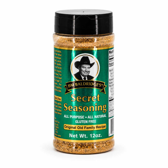 A 12 oz plastic shaker bottle of Jim Baldridges Secret Seasoning with a black lid and a green label, shown on a white background.