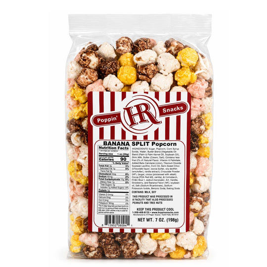 A 7 oz bag of Poppin' IR Snacks Banana Split Popcorn, featuring a clear plastic bag filled with a mix of white, yellow, pink, and brown popcorn pieces, complete with a red and white striped label.