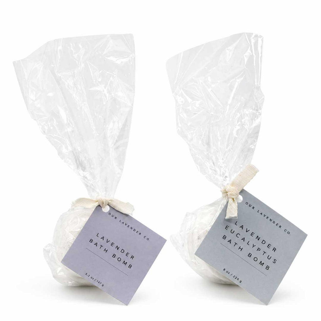 Two lavender bath bombs in clear plastic bags with labels on a white background