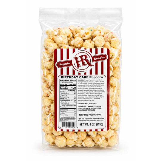 A 8 oz bag of Poppin' HR Snacks Birthday Cake Popcorn on a clean white background. The clear plastic bag shows the golden-yellow popcorn inside, with a prominent red and white striped label on the front.