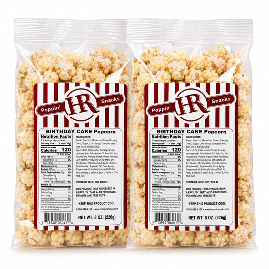 Two clear plastic bags of Poppin' R Snacks Birthday Cake Popcorn shown side by side on a white background, displaying the front and back labels.