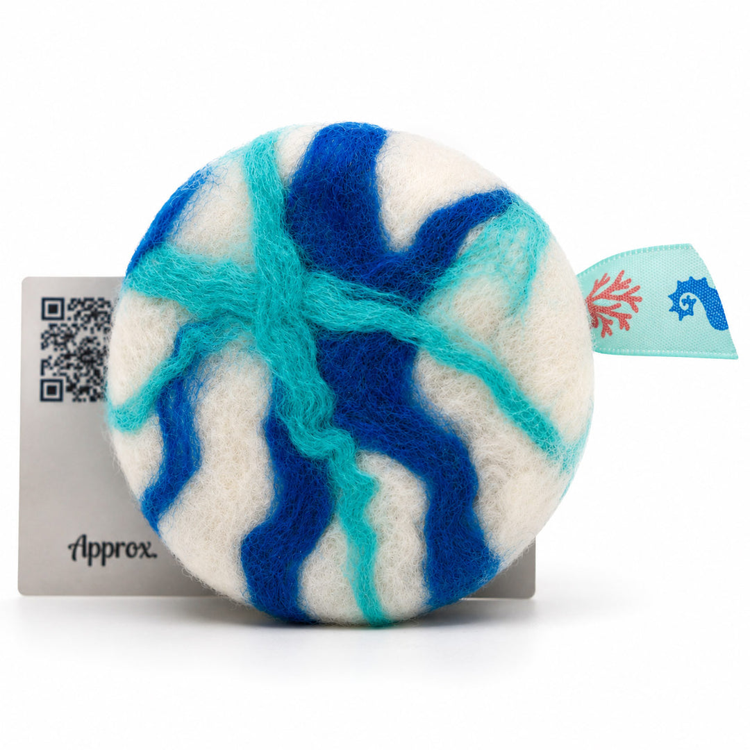 Round felted product with blue and green patterns on a white background