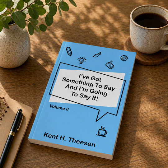 Book titled 'I've Got Something To Say And I'm Going To Say It!' by Kent H. Theesen on a wooden table with a cup of coffee and plant.